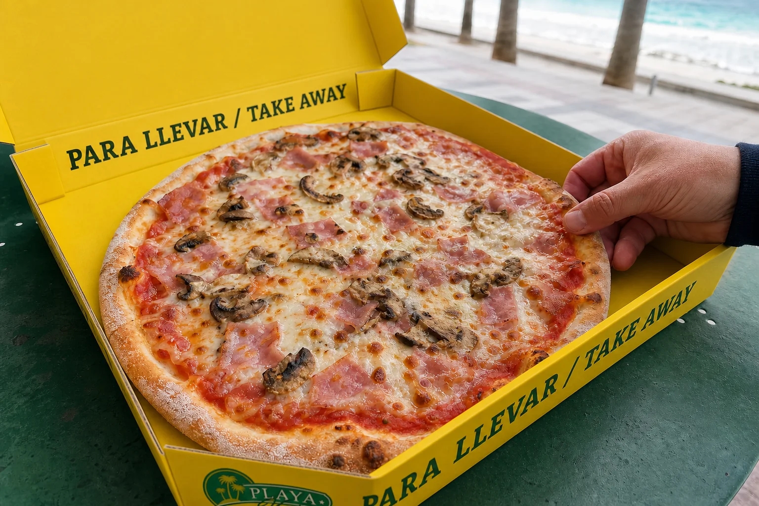 Artisan pizza in the yellow Playa Verde takeaway box